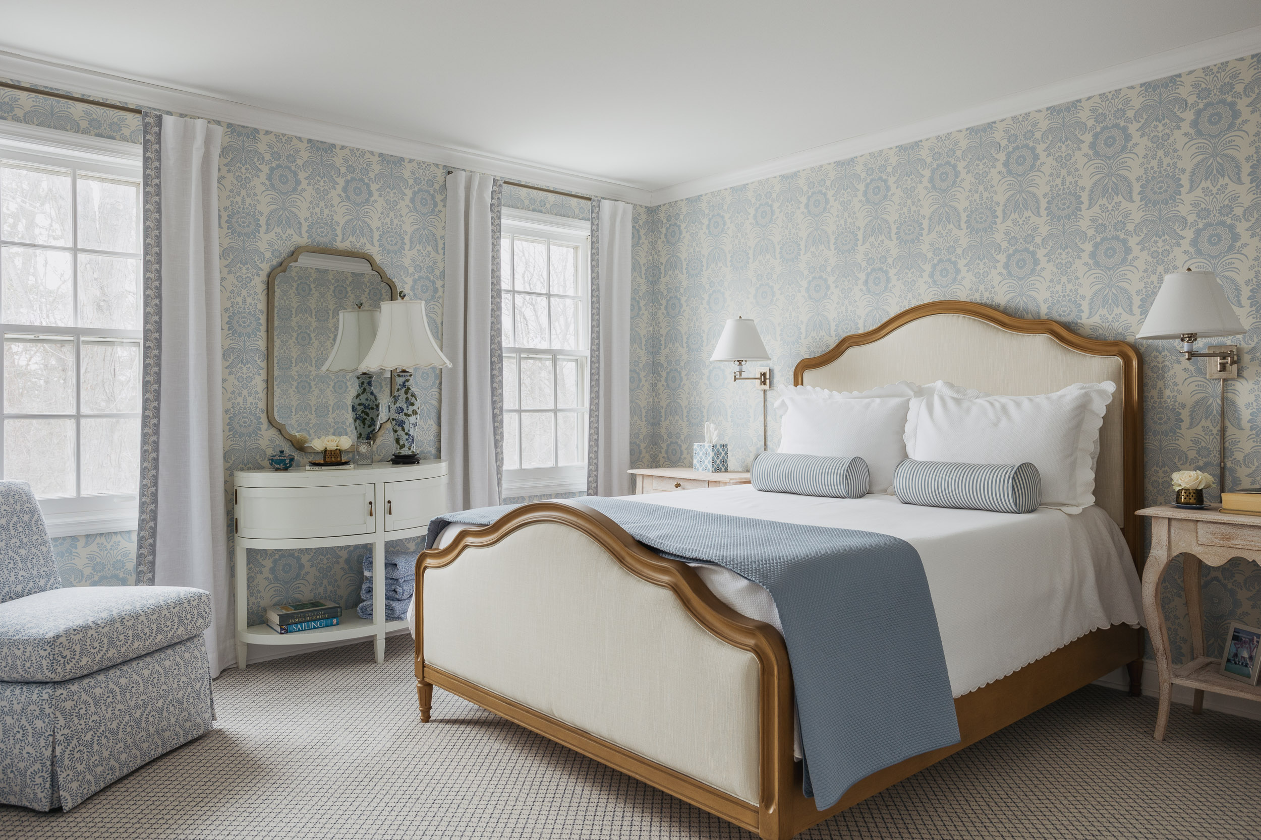 Elegant bedroom with blue and white wallpaper, featuring a classic bed and matching decor